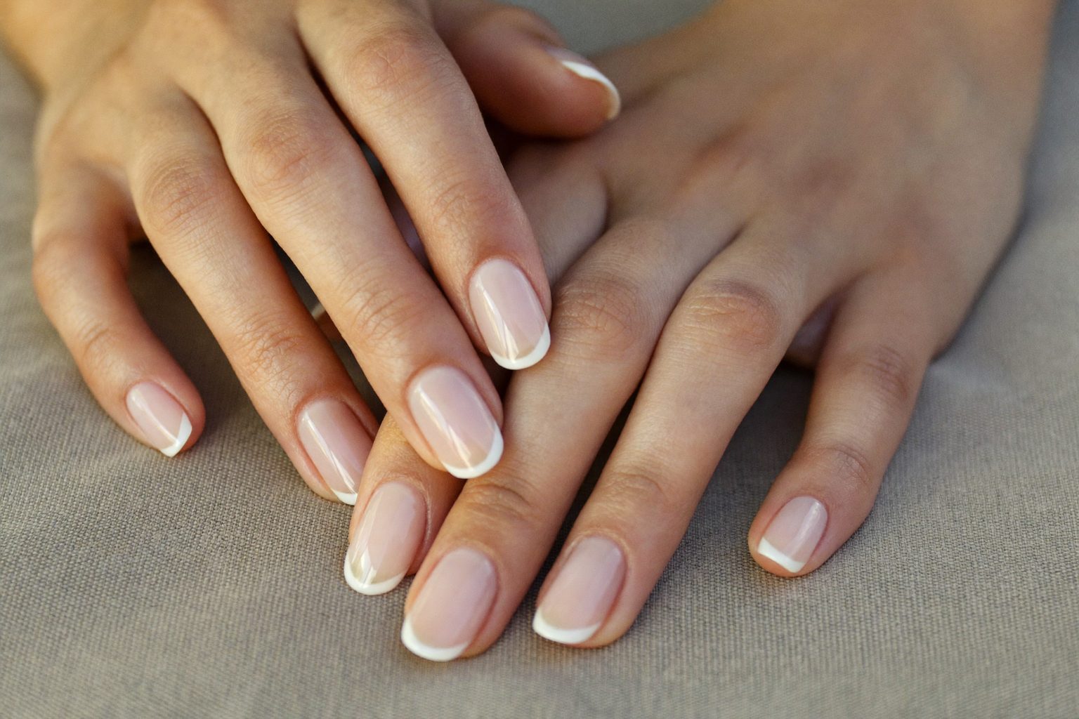 Nagelstyliste werkt geconcentreerd aan de manicure van een klant in een lichte salon