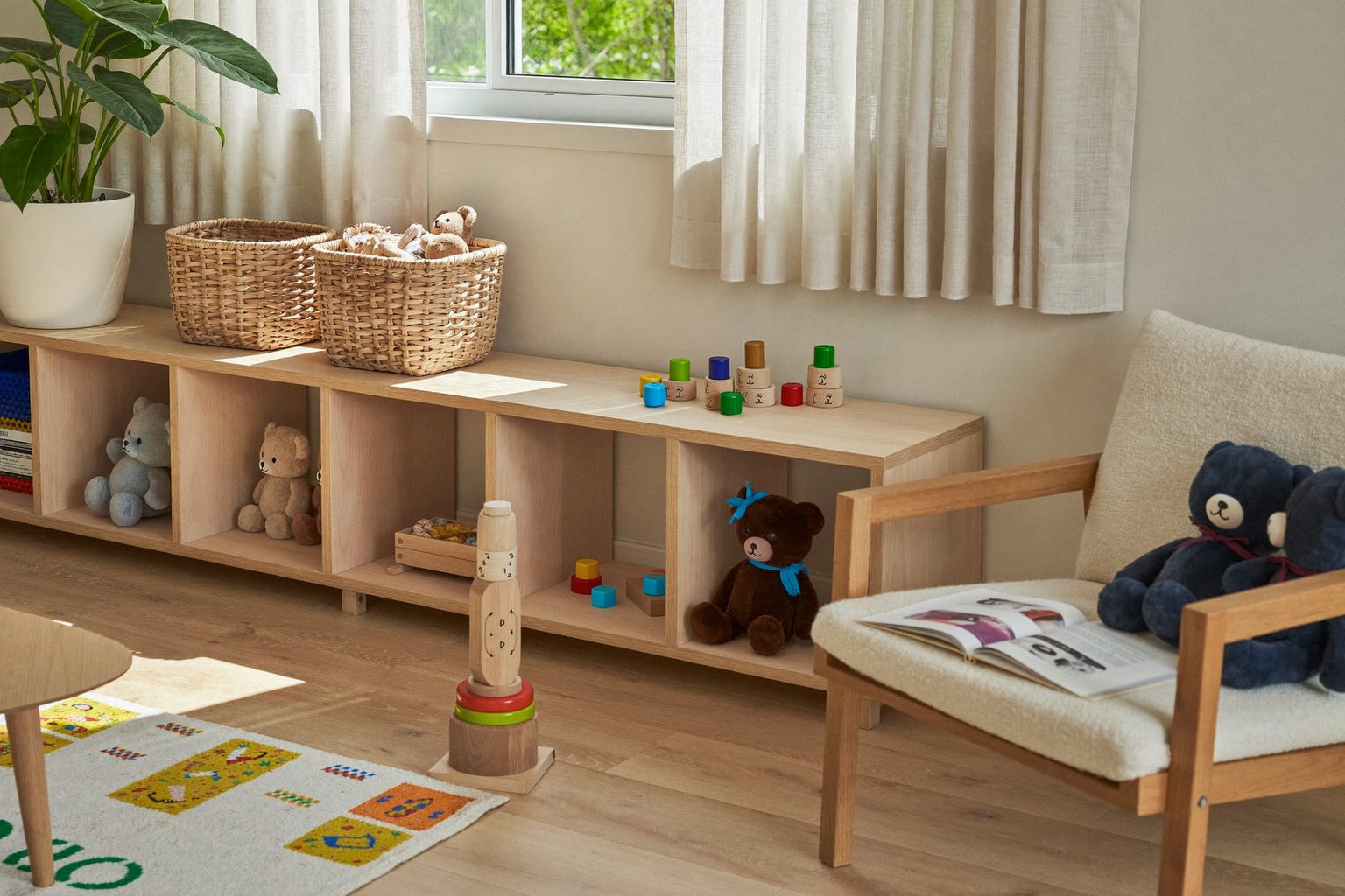 Een lichte, opgeruimde speelhoek in een kinderdagverblijf met houten speelgoed, knuffels en een leeshoek